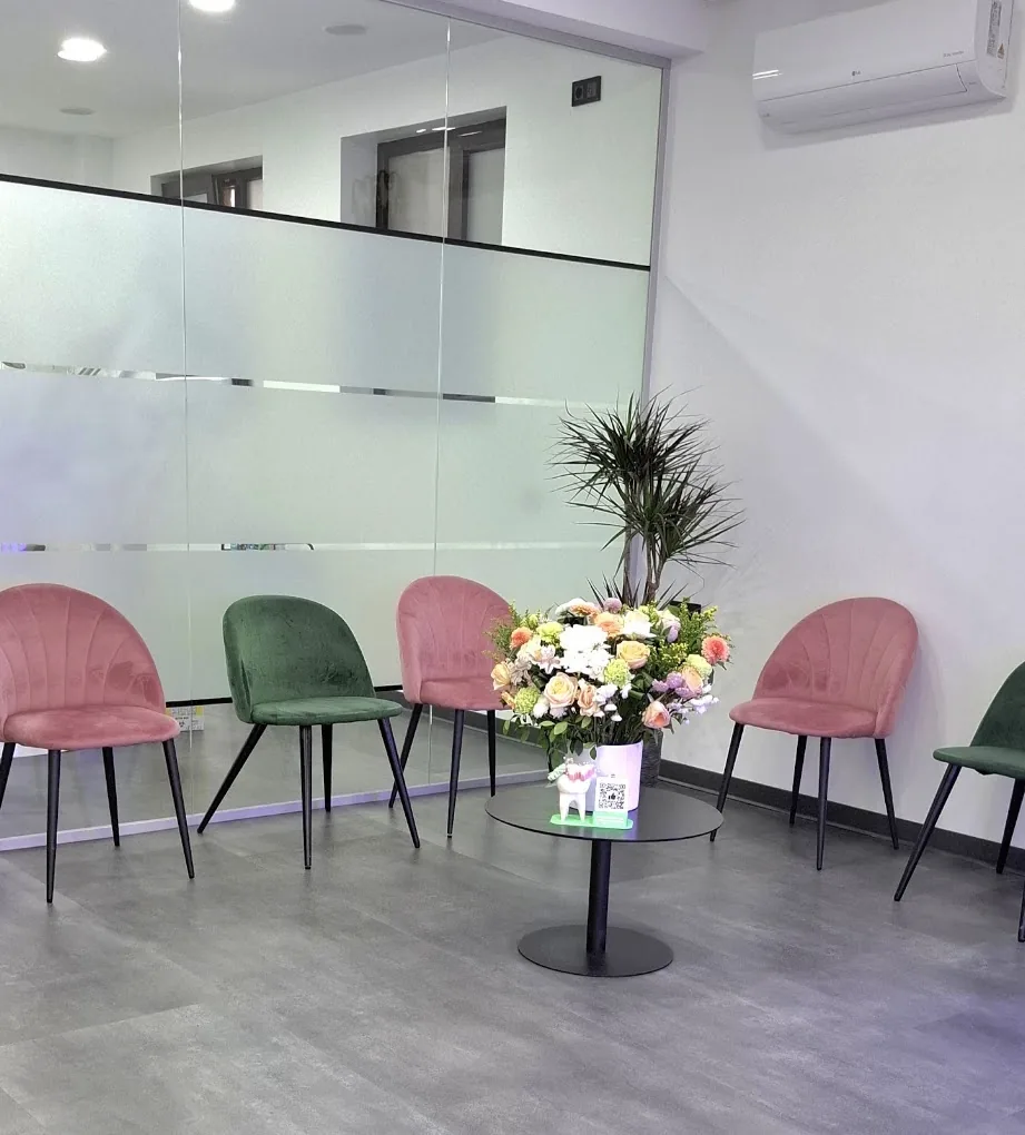 Sala de așteptare a clinicii, cu fotolii roz și verzi